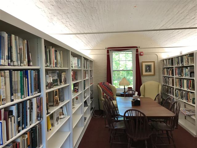 Built-in library shelving lining a long room