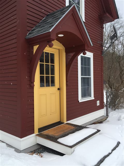 Custom entry canopy over a yellow door