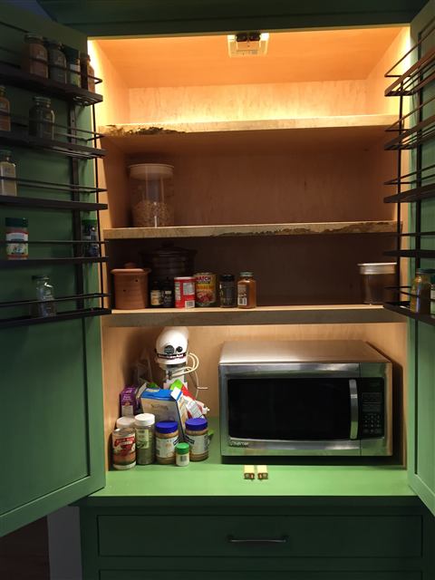 Painted cabinet with a lit interior, shelves, and spice racks