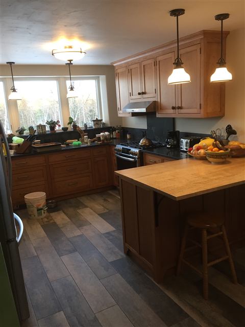 Kitchen with wood cabinets, pendant lights, and a butcher-block island