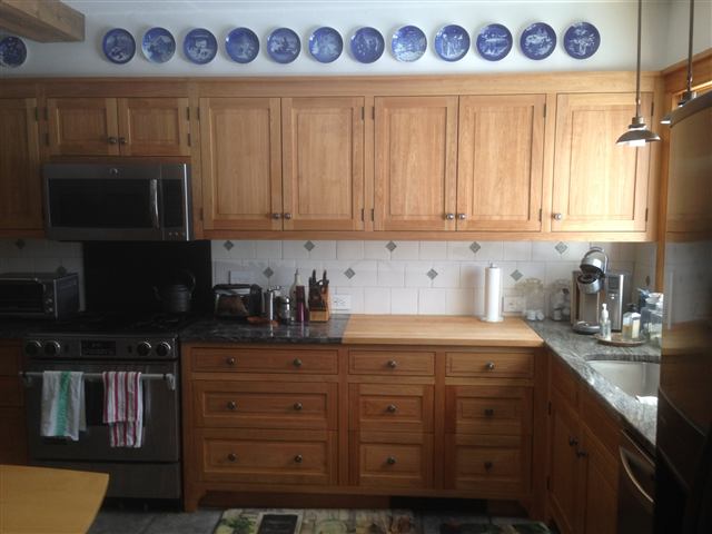 Kitchen with wood cabinets and a display-plate rail