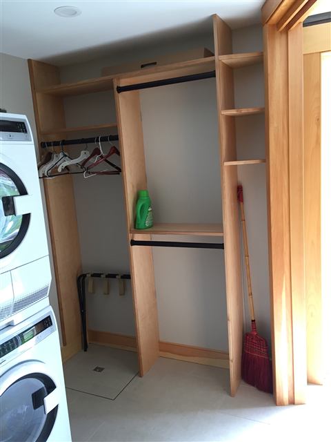Custom laundry closet shelving with hanging rods