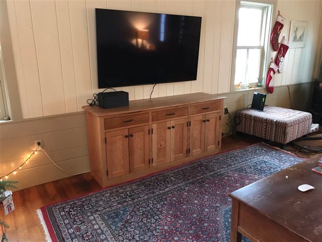 Custom media cabinet beneath a wall-mounted television