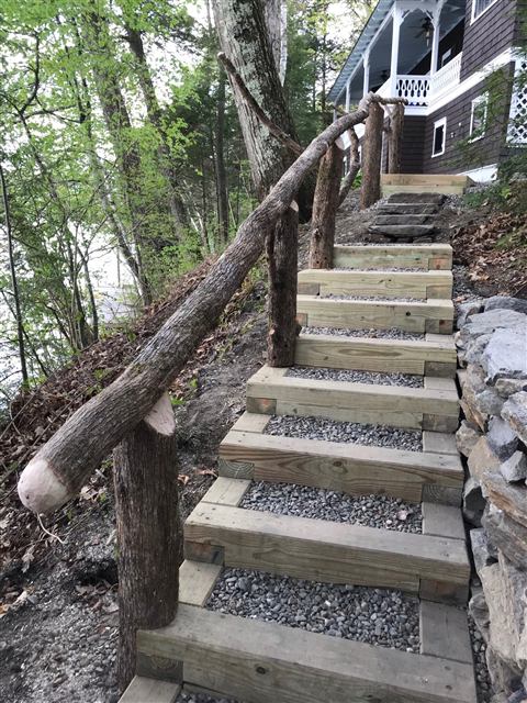 Timber steps with a rustic log railing on a hillside