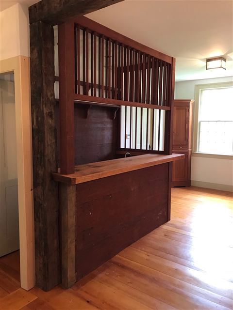 Reclaimed-wood bar and room divider with a spindle screen