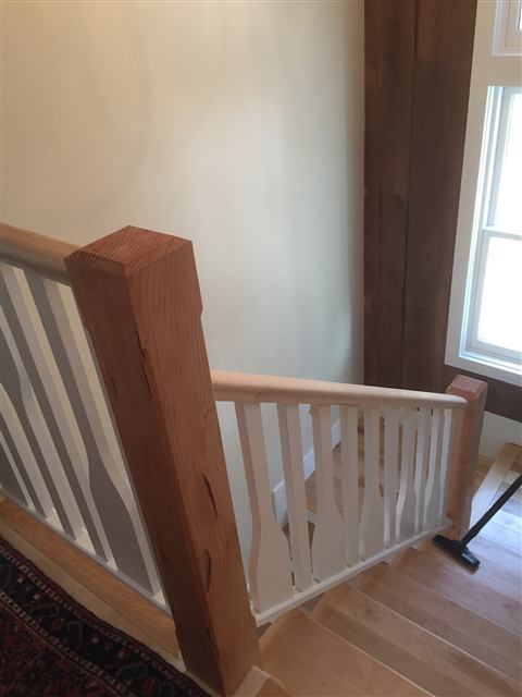 Timber newel post and painted railing at a stair landing