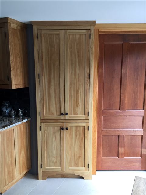 Tall two-door cabinet with an arched base