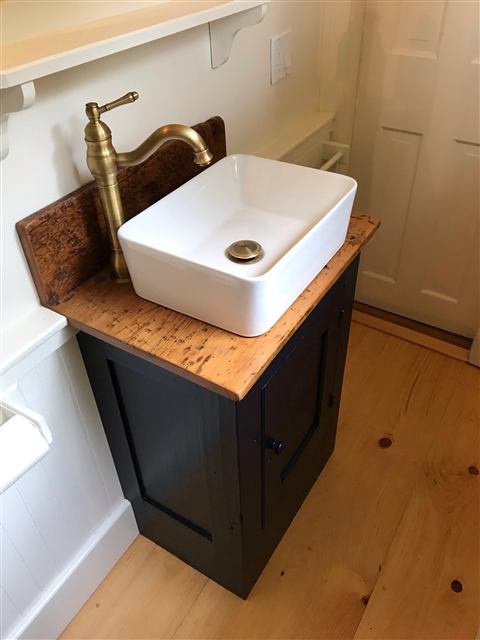 Black painted vanity with a reclaimed wood top and vessel sink